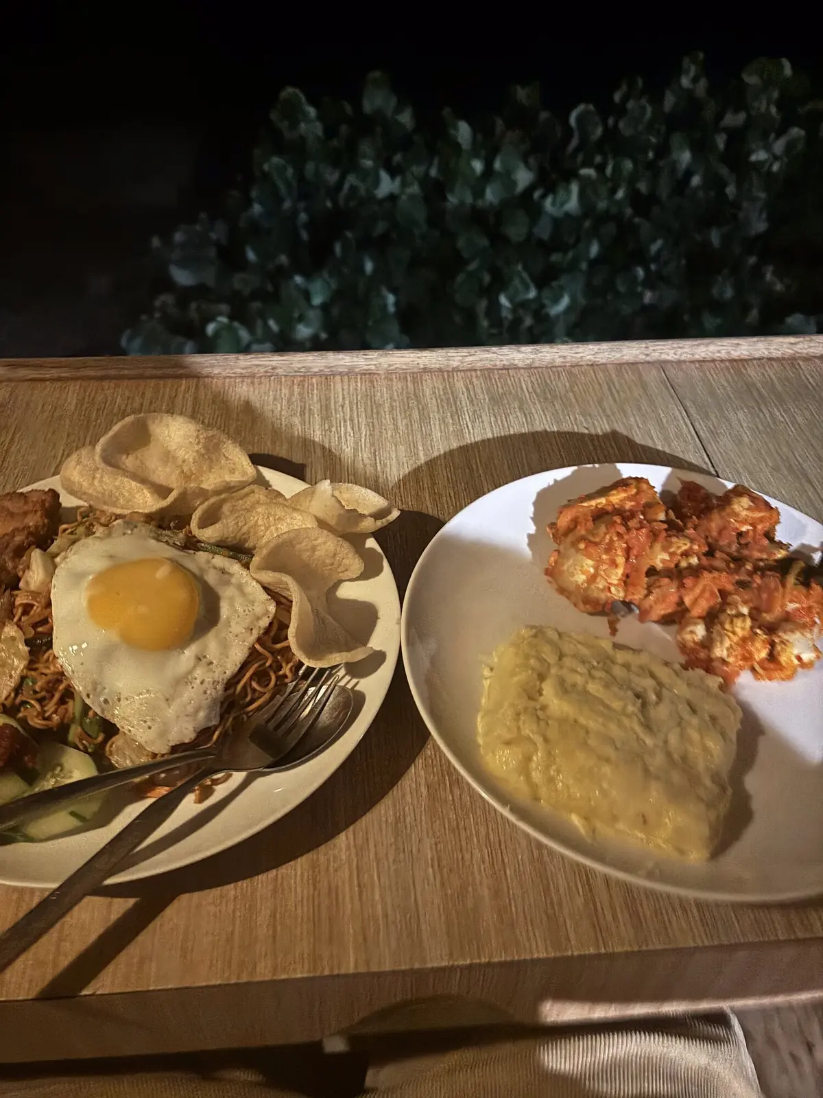 Evening dinner of nasi goreng with fried egg, prawn crackers, grilled prawns and mashed potato at an outdoor table in Lakey Peak
